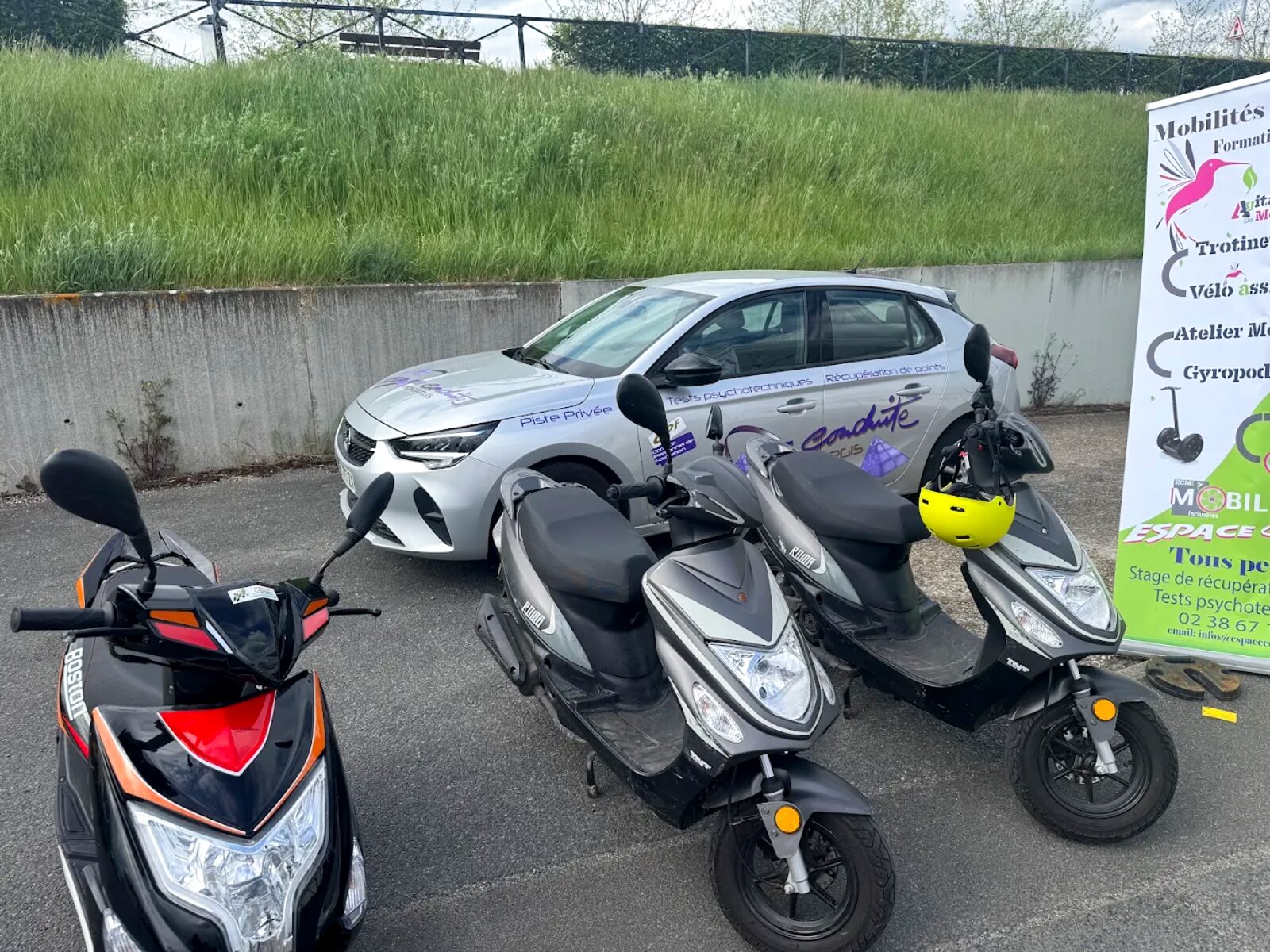 Scooters et voiture école sur la piste privée